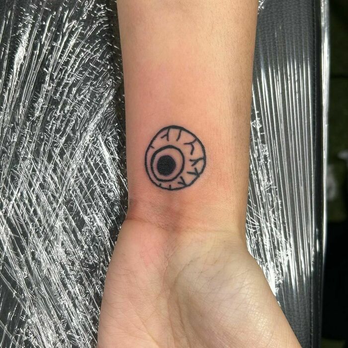 Simple eyeball wrist tattoo on skin, creating a bold statement.