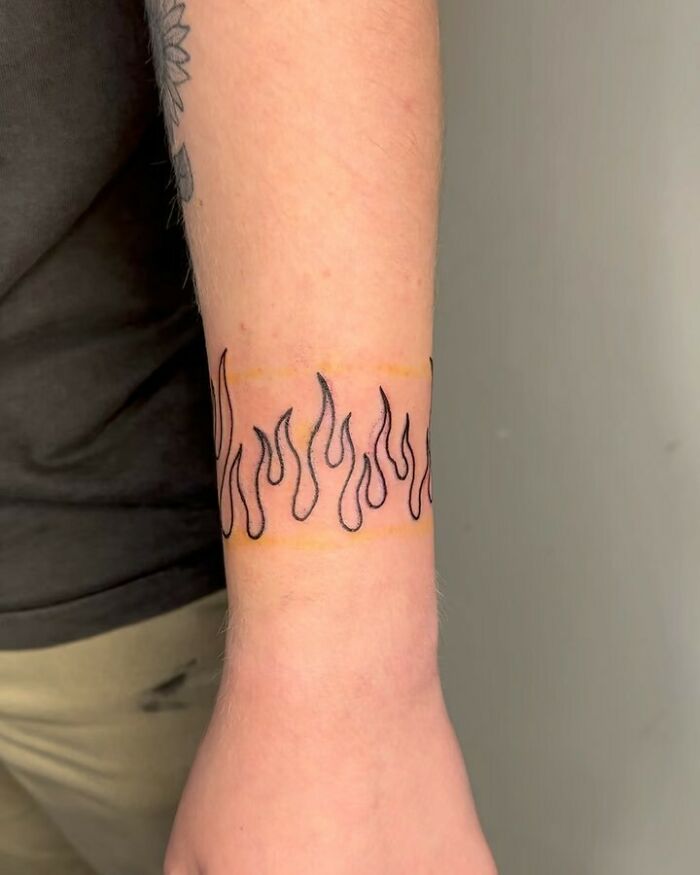 Wrist tattoo with flame design, offering a stylish and timeless accessory idea.
