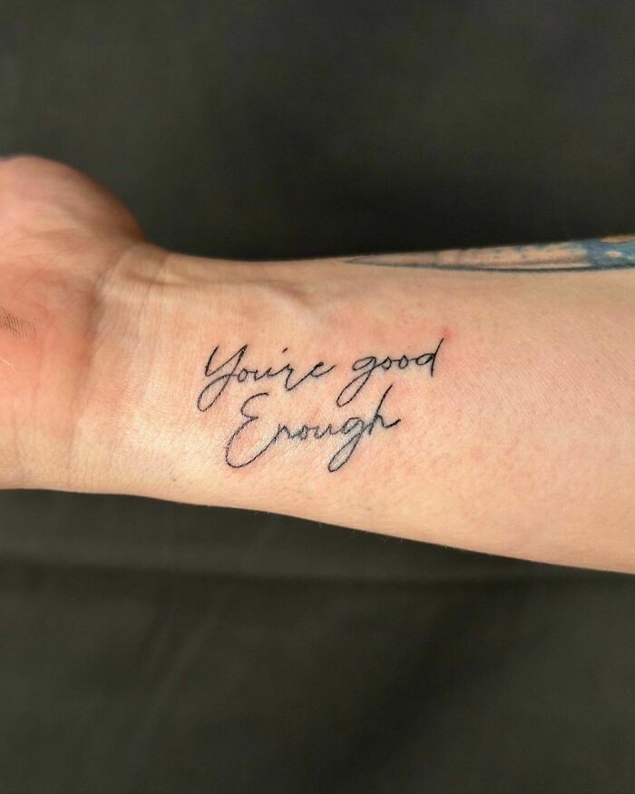 Wrist tattoo design with handwritten phrase "You're good enough" in black ink.