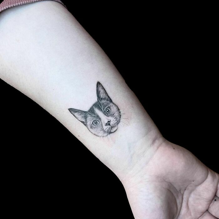 Cat-inspired wrist tattoo design with detailed shading.