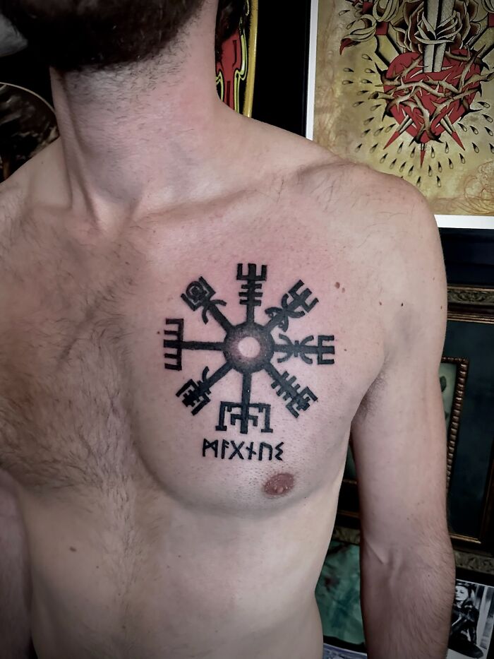 A detailed Nordic tattoo design on a man's chest, featuring intricate symbols and runes.