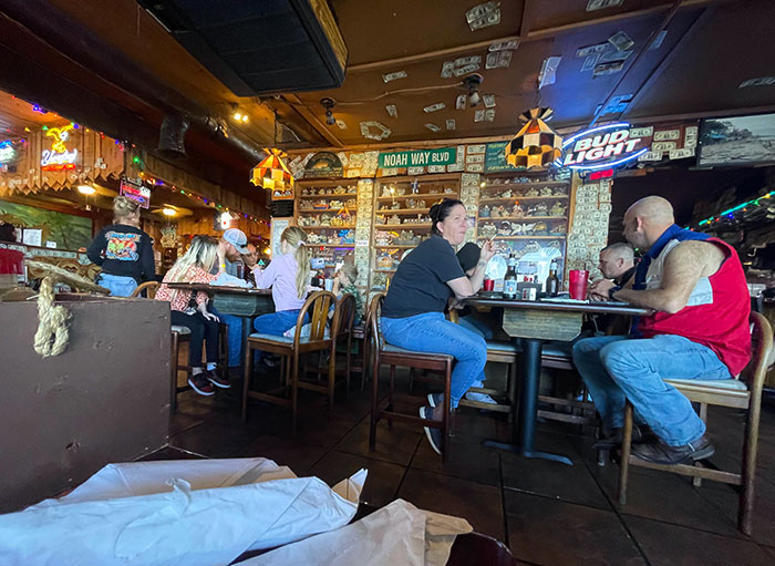 These People Smoking Cigarettes Inside Next To A Table Of Children