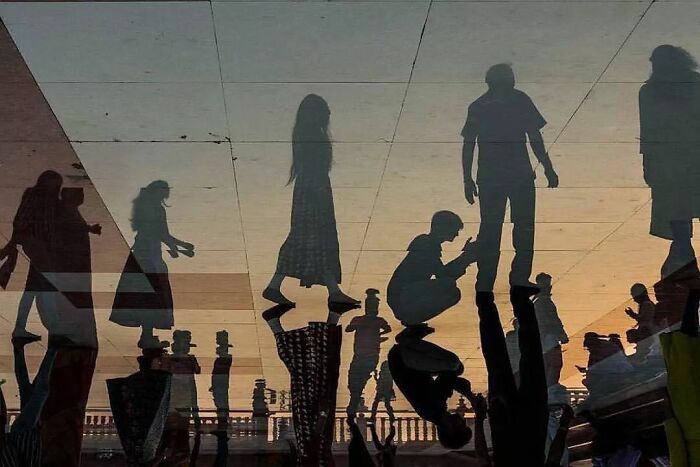 Shadows of people in various poses against a sunset background, creating an amusing visual effect on Instagram.
