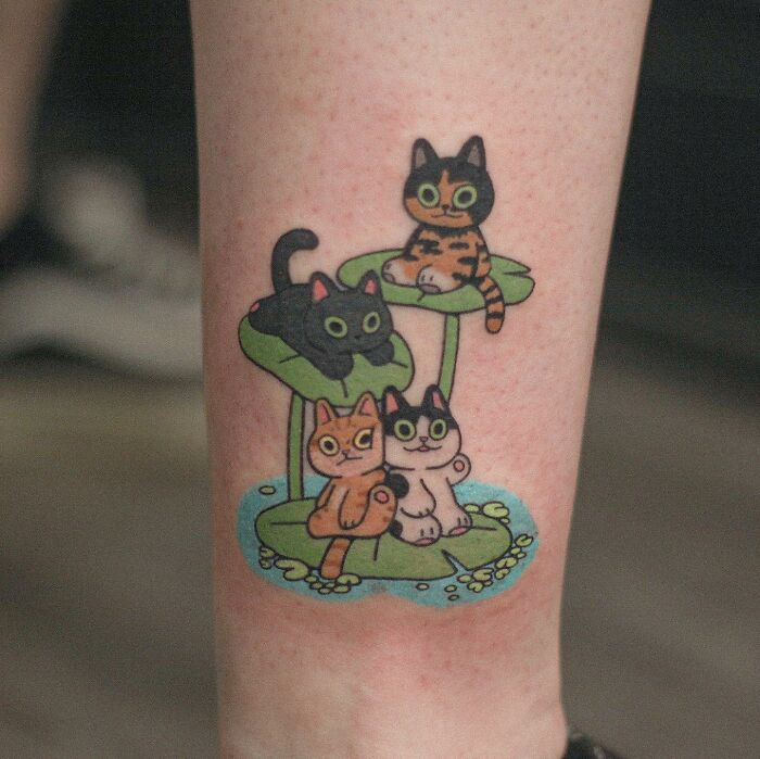 Adorable animal-themed tattoo featuring colorful cats on lily pads.