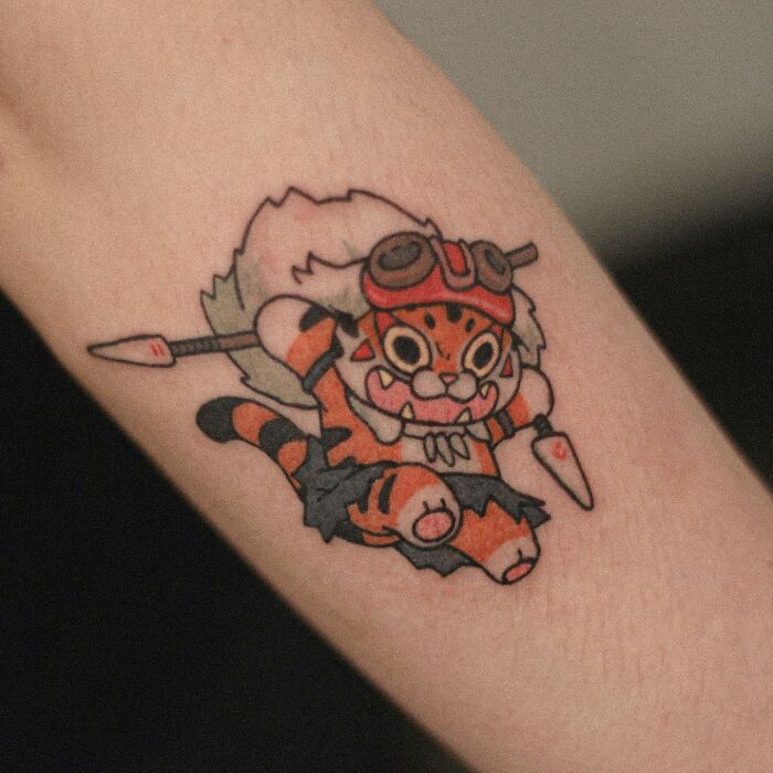 Adorable animal-themed tattoo of a cartoon-like tiger design on forearm.