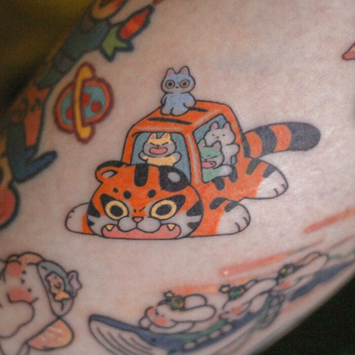 Adorable animal-themed tattoo of cartoon animals in a tiger-shaped car on skin.
