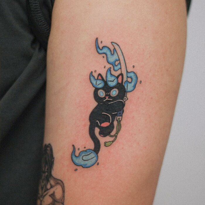 Tattoo of an adorable black cat with blue flames and sword, showcasing animal-themed design.