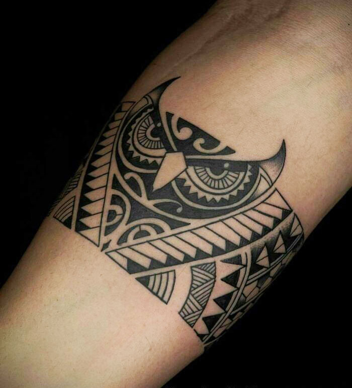 Geometric owl armband tattoo design on forearm.