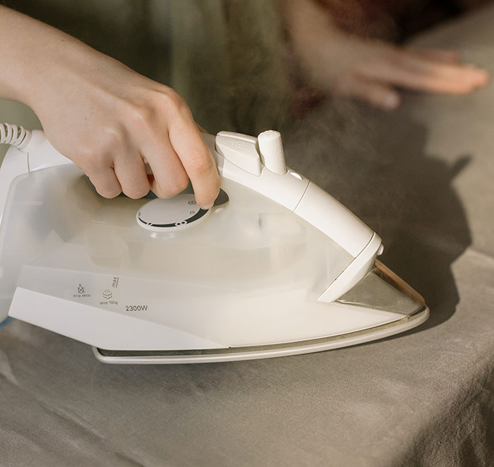 Person holding white clothes iron