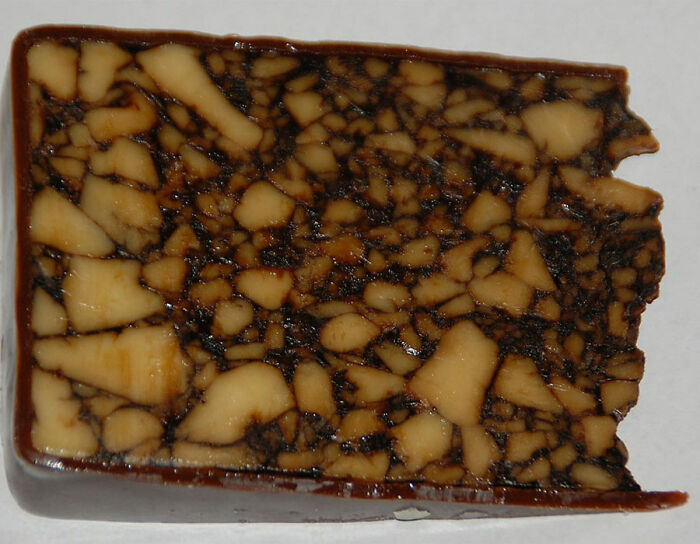 a piece of white and brown cheese