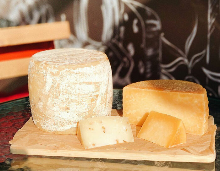 two view of cheese on a wooden board