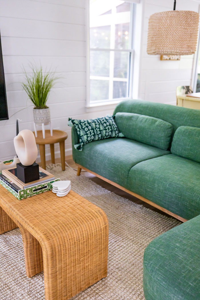 Cozy living room with green sofa, wicker table, and decorative accents for creative decoration inspiration.