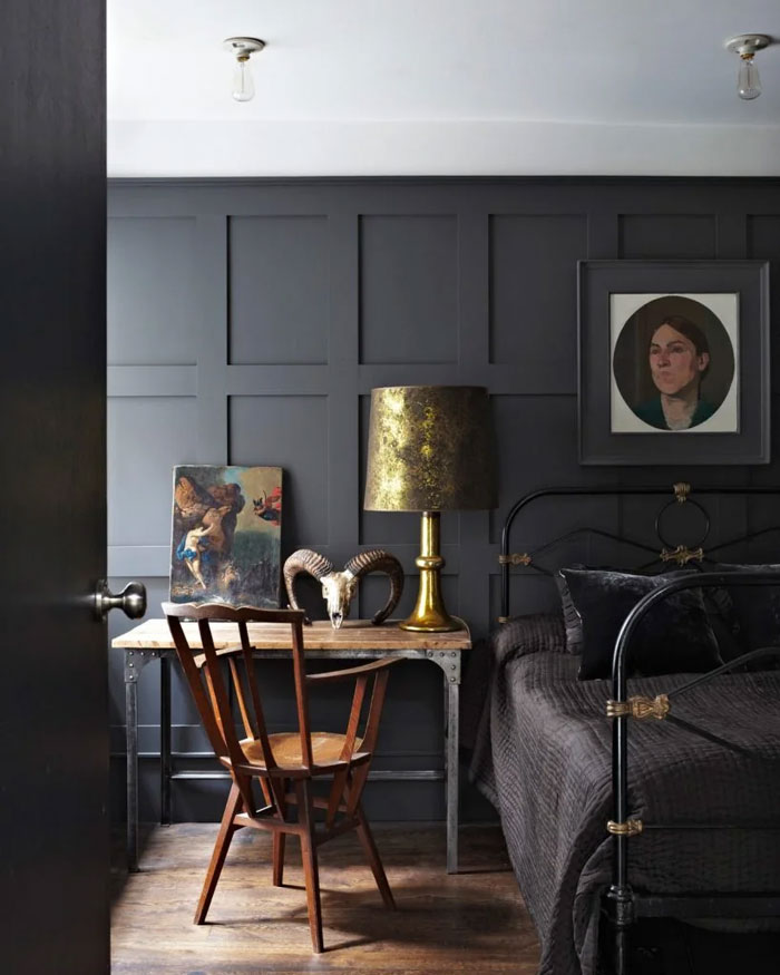 Creative inspiration in a moody bedroom with dark walls, vintage decor, artwork, and a metal bed frame.