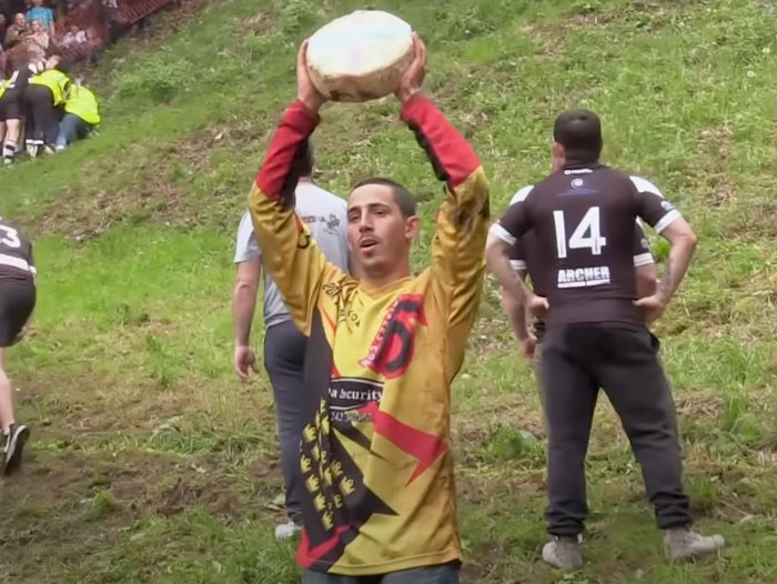Man holding a cheese above his head