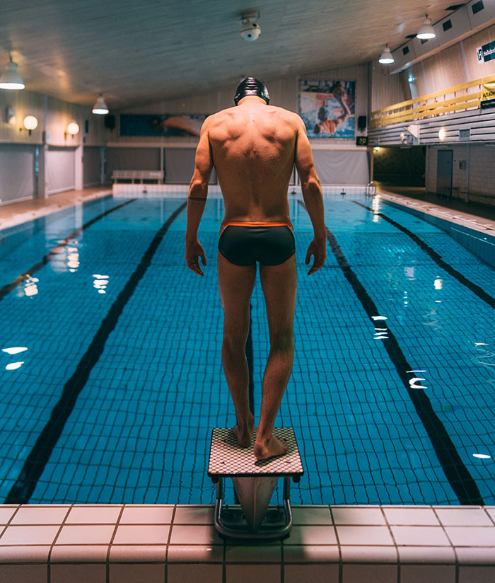 Man standing at platform near swimming pool