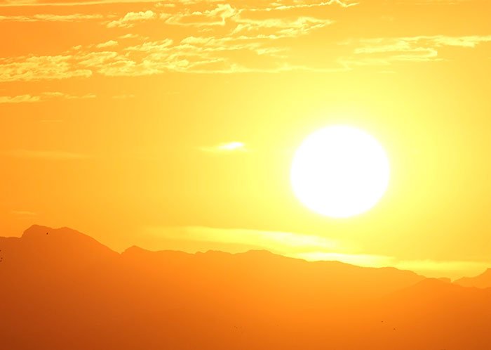 Sunset over mountain range illustrating concepts related to physics in nature and light energy phenomena.