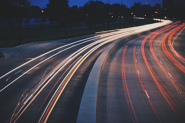 Light trails on a highway at night illustrating fast traveling that relates to fun facts about physics concepts.