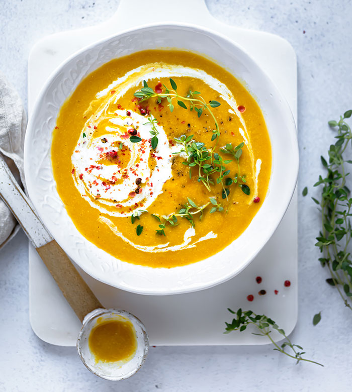 Creamy soup in a white bowl garnished with herbs and spices, inviting curiosity about fun facts in physics.