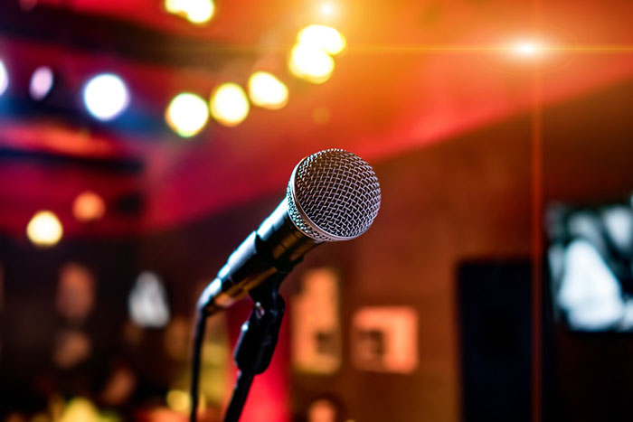 Microphone on stage with colorful lights, perfect for pursuing fun hobbies like singing or public speaking.