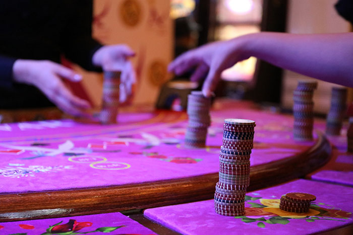 People engaged in a fun hobby, playing a board game with stacks of chips on a colorful table.