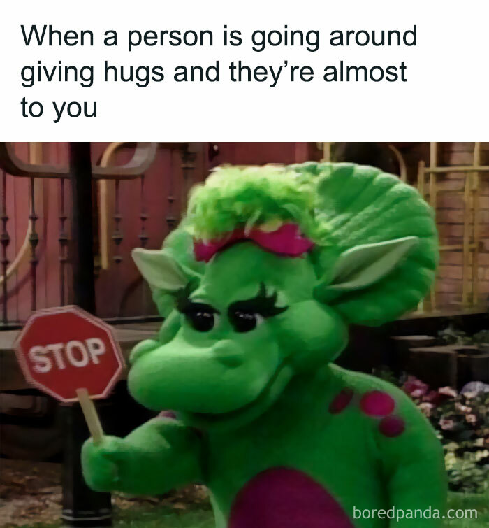 Green dinosaur with a stop sign humorously illustrates a spicy meme about avoiding unwanted hugs.