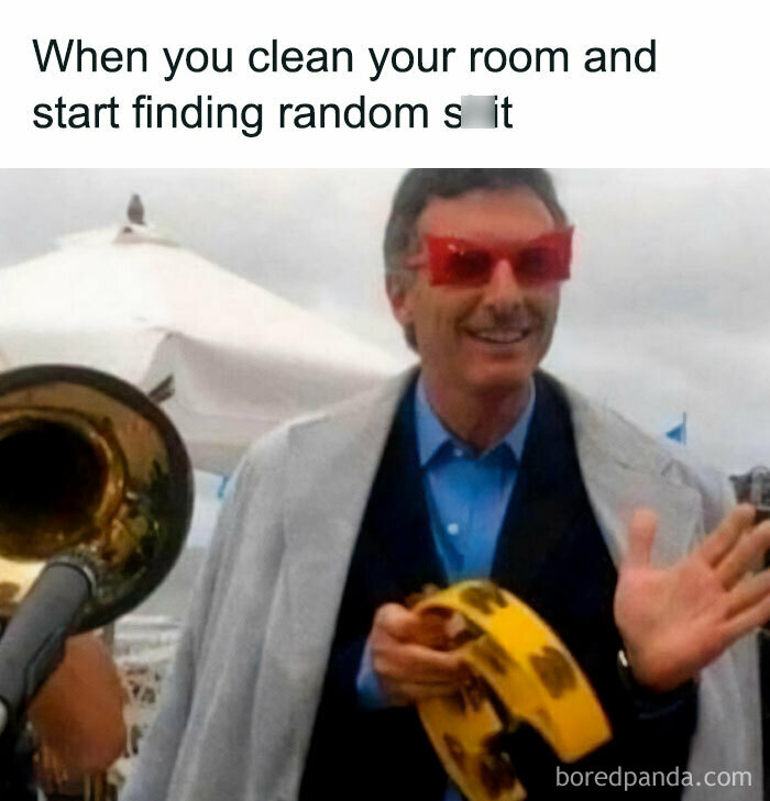 Man with red glasses holding a tambourine, smiling; humorous meme about finding things while cleaning. Spicy memes theme.