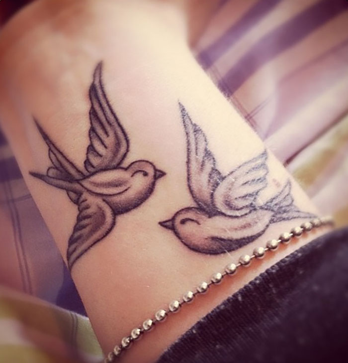 Two birds wrist tattoo design, showcasing a statement tattoo idea.