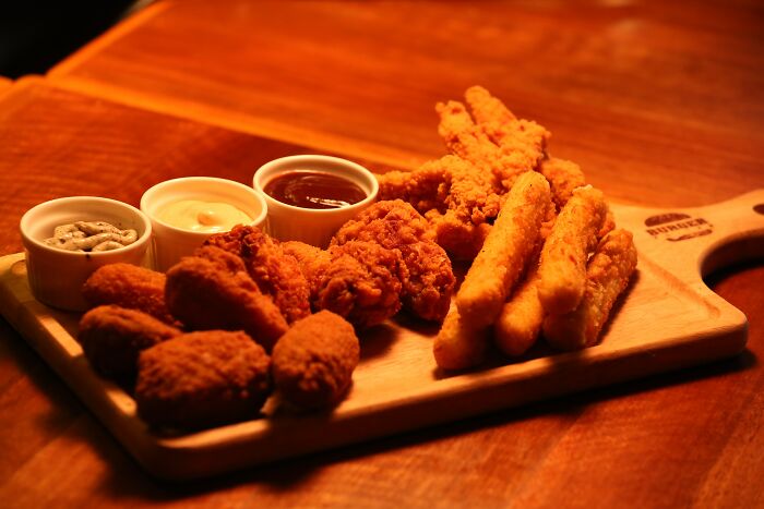 Picture of fried chicken, sauces and mozzarella sticks on plate