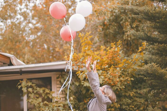 Woman Letting Go Balloons In The Sky 