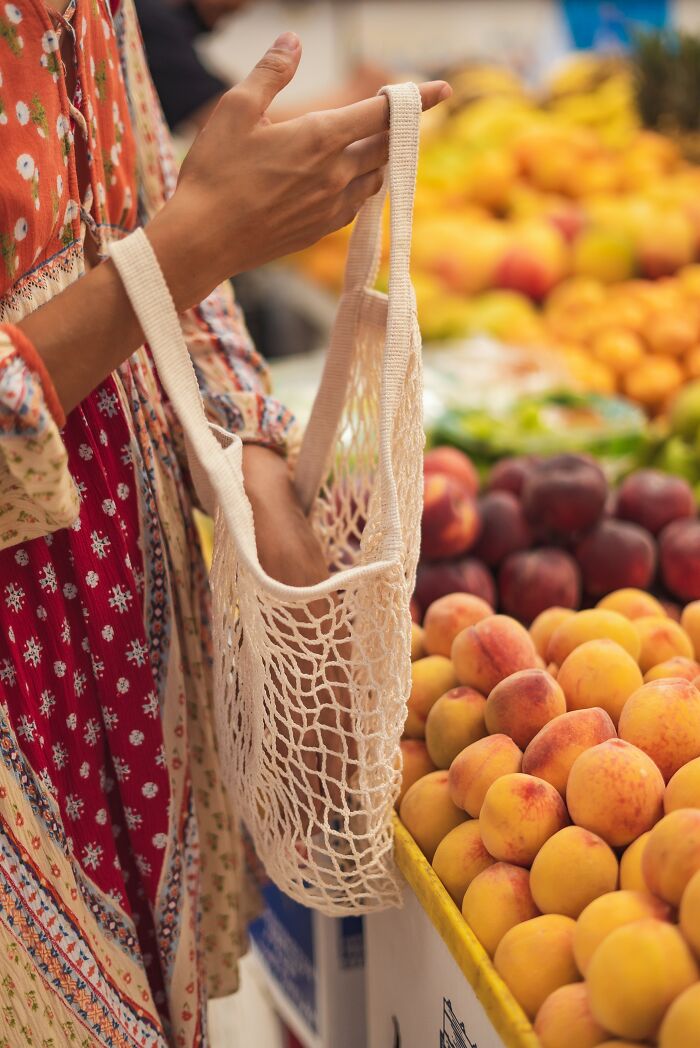 Person Putting Fruit In A Bag 