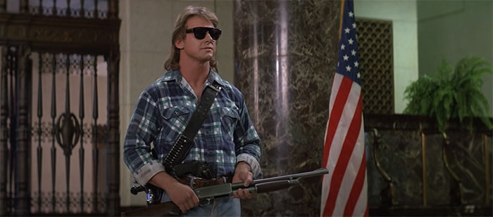 Nada standing with a gun