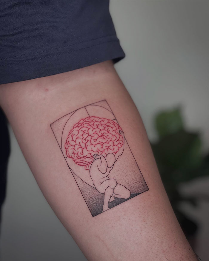 Red ink tattoo of a figure holding a brain on an arm, showcasing unique artistry.