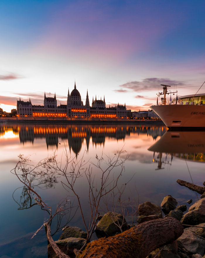 River with a massive lit up building in the evening 