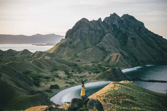 Woman standing on the mountain above the ocean 