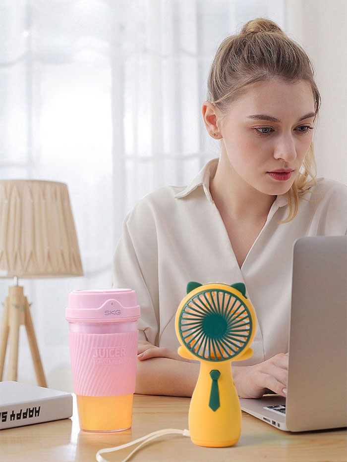 Pink cup and yellow handheld fan 