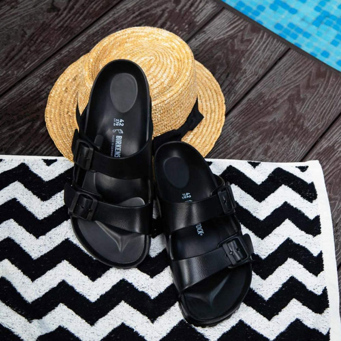 Black Birkenstocks on a towel 
