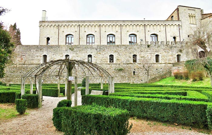 evenly trimmed green bushes in front of an old building