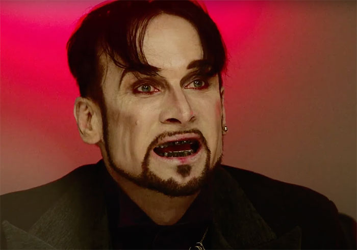 Rib wearing suit and looking in Blood Drive