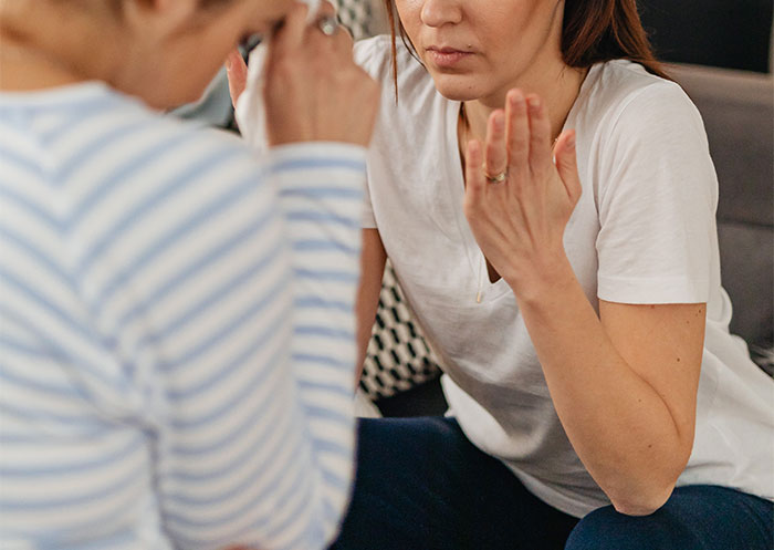 a woman in a white shirt looking at another woman a woman in a white shirt looking at another woman