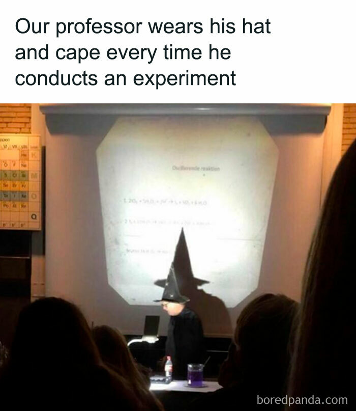 University professor conducts experiment wearing a wizard hat and cape in front of a class, projecting notes. 