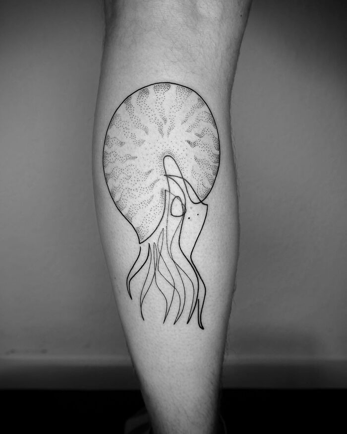 Single line tattoo of a squid on a person's leg, showcasing captivating minimalist artistry.