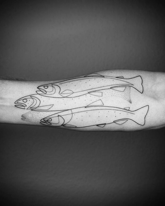 Minimalist single-line tattoo of fish on an arm, showcasing captivating tattoo design.