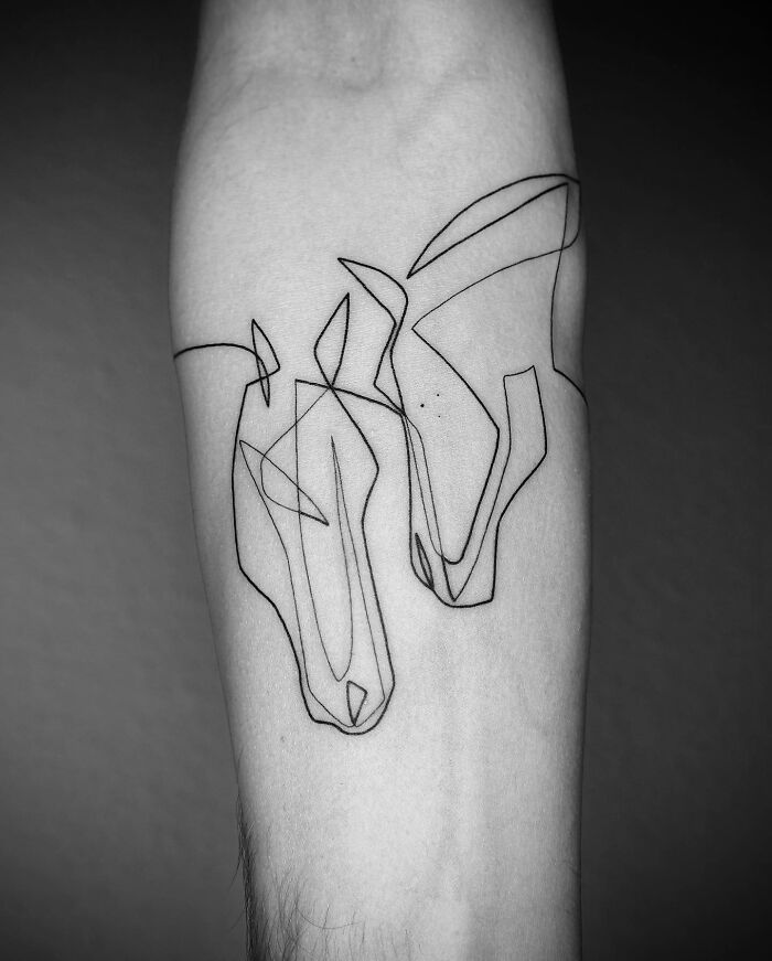 Single line tattoo of two horses on a person's arm, showcasing captivating artistry.