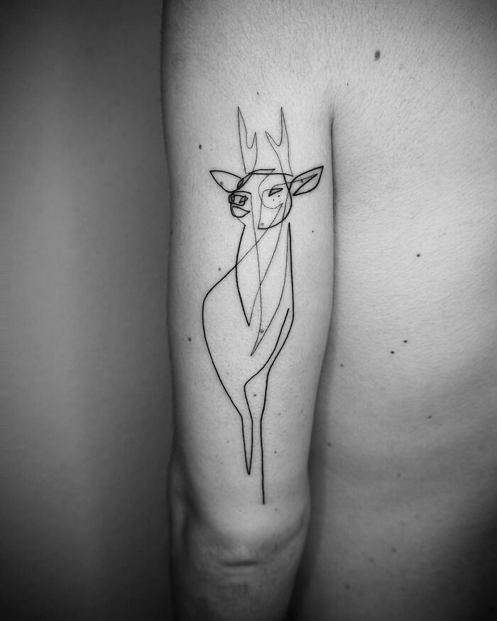 Single line tattoo of a minimalist deer on an arm, showcasing captivating tattoo art.