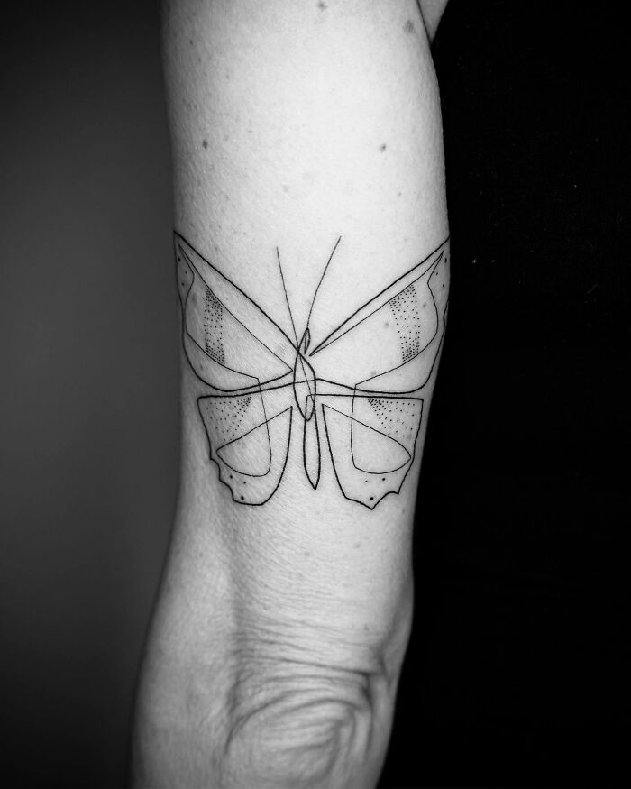 Single line butterfly tattoo on a person's arm, showcasing captivating tattoo artistry.