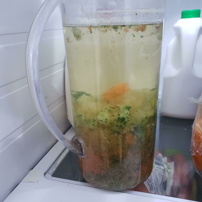 Unappetizing food pic of a fridge pitcher with cloudy liquid and floating particles.