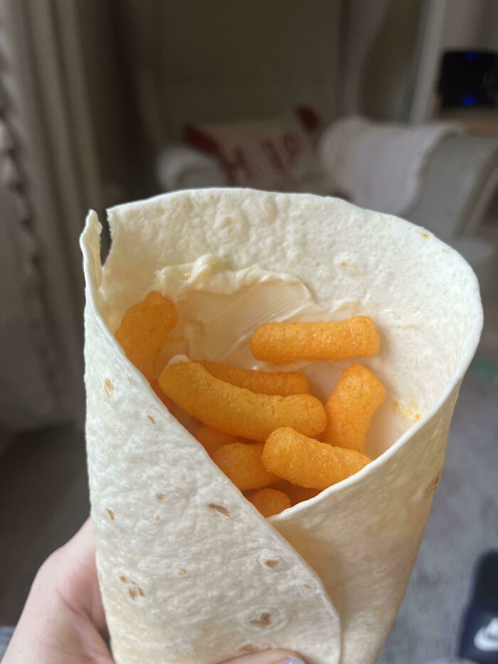 Tortilla filled with cheese puffs and cream cheese, showcasing a horrible food combination.
