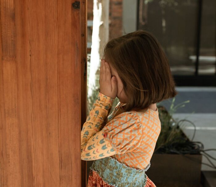 Little girl playing hide and seek