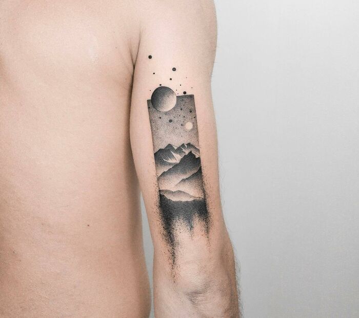 Tattoo of a mountain landscape and celestial elements on an arm, showcasing the human-earth bond through nature art.