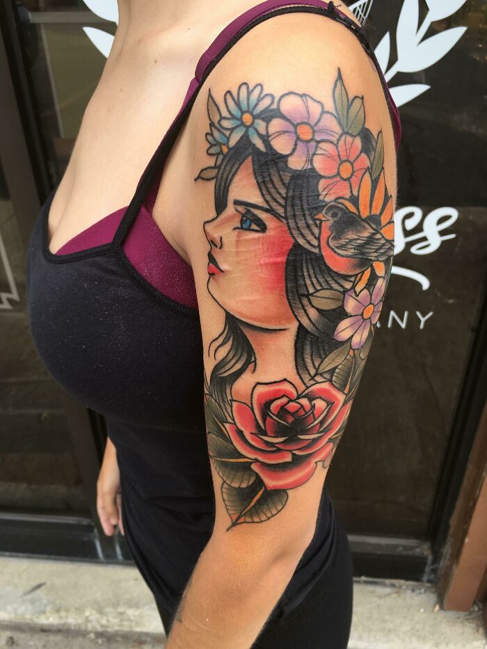 Colorful nature tattoo featuring a woman's profile with flowers and a bird, celebrating the human-earth bond.